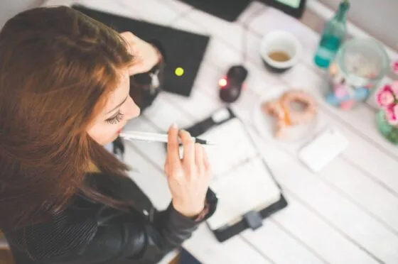 Woman working at desk with notebook