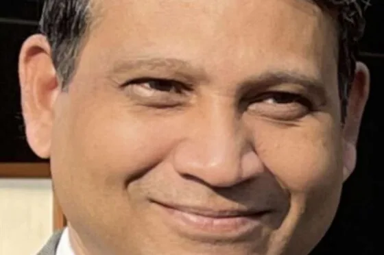 Man wearing suit and tie smiling at camera