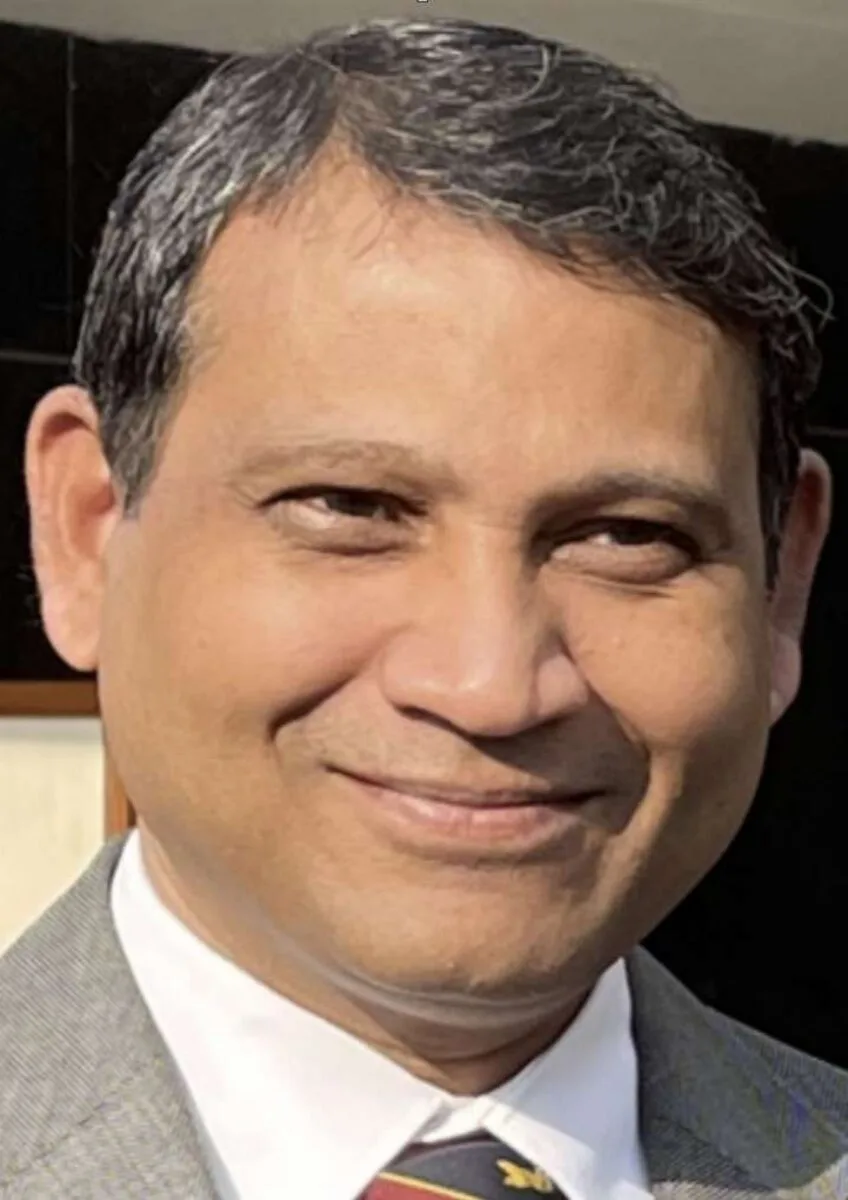 Man wearing suit and tie smiling at camera
