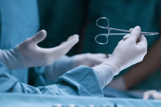 Hands of medical professional holding surgical instrument in operating room