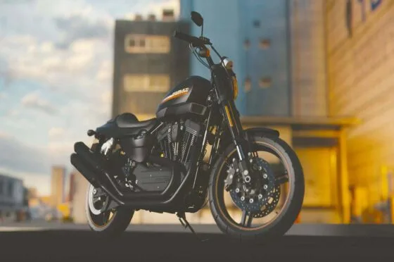Black motorbike parked outdoors with blurred urban background