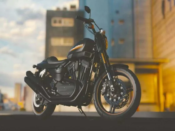 Black motorbike parked outdoors with blurred urban background