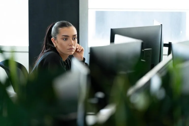 Female sat at desk looking at monitors