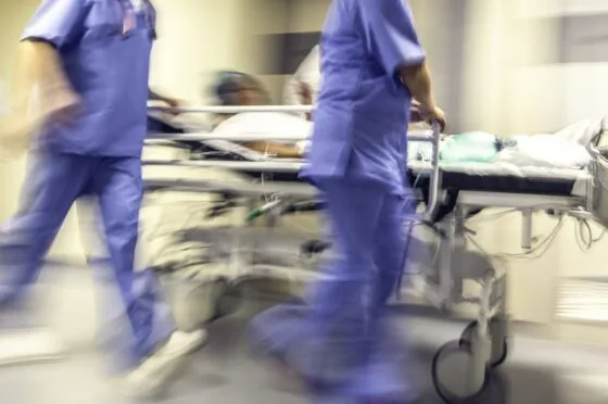 Blurred hospital corridor with medical staff pushing patient on trolley