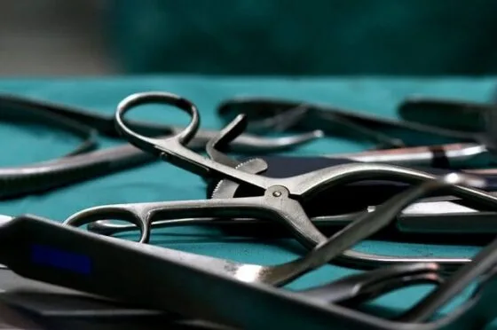 Close-up of surgical instruments laid out on sterile green drape