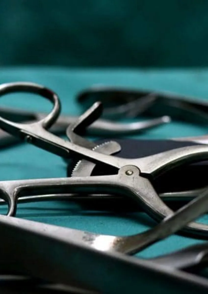 Close-up of surgical instruments laid out on sterile green drape