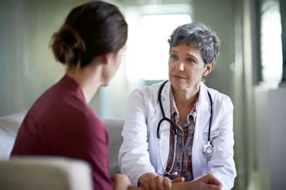 Female doctor listening attentively to a female patient in a consultation room