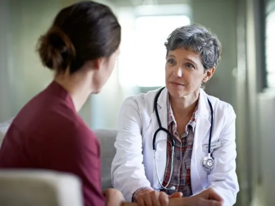 Female doctor listening attentively to a female patient in a consultation room