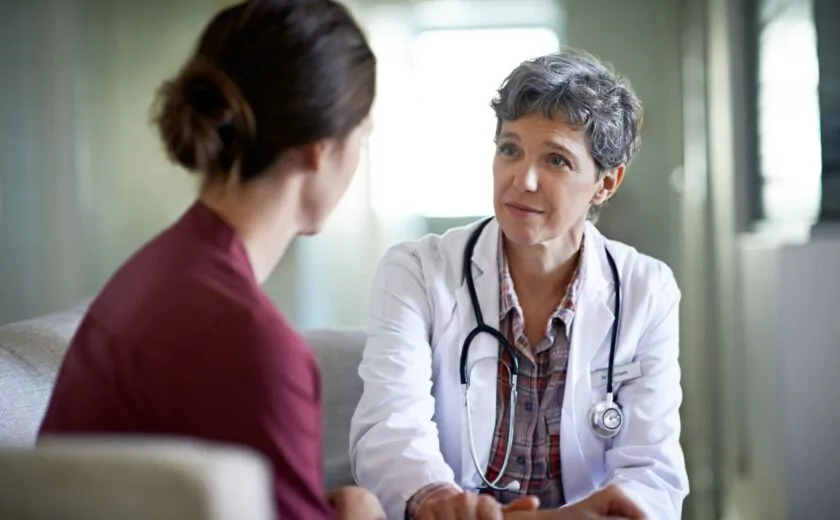 Female doctor listening attentively to a female patient in a consultation room