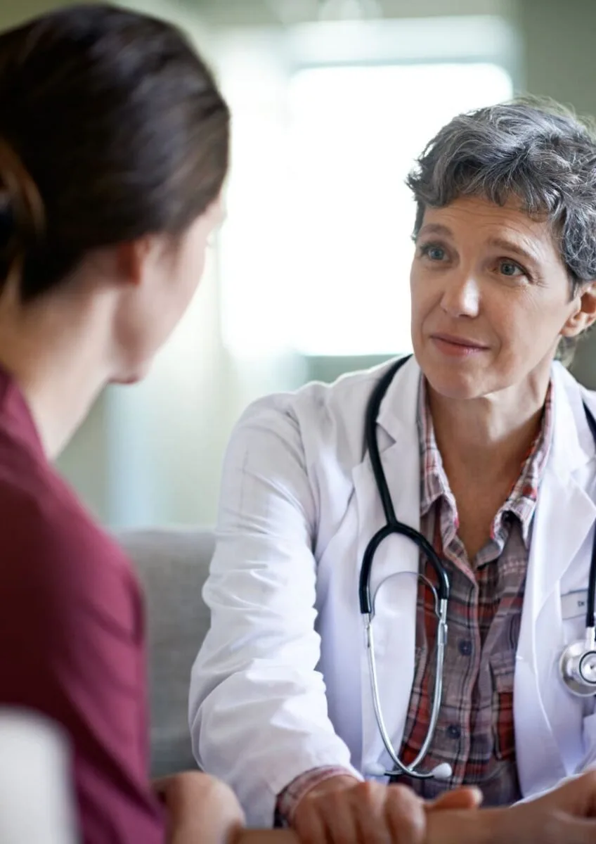 Female doctor listening attentively to a female patient in a consultation room