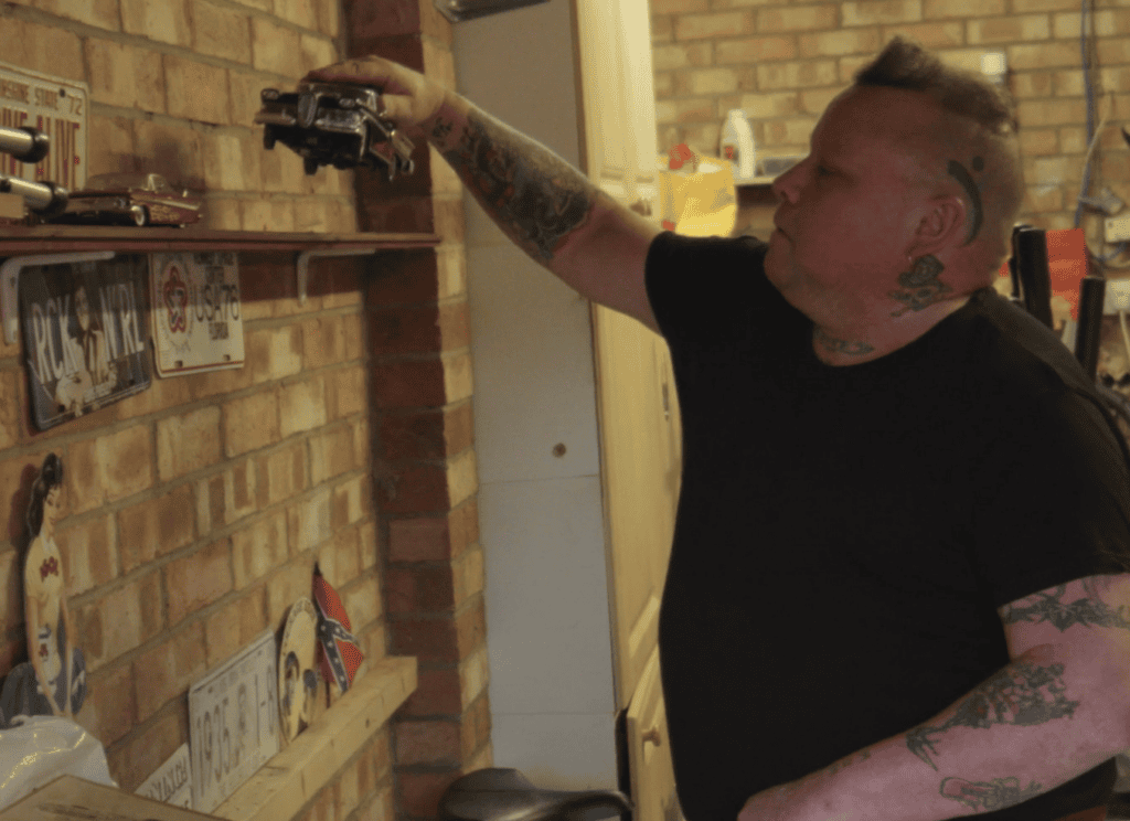 Robert in his garage putting a model car on his display shelf