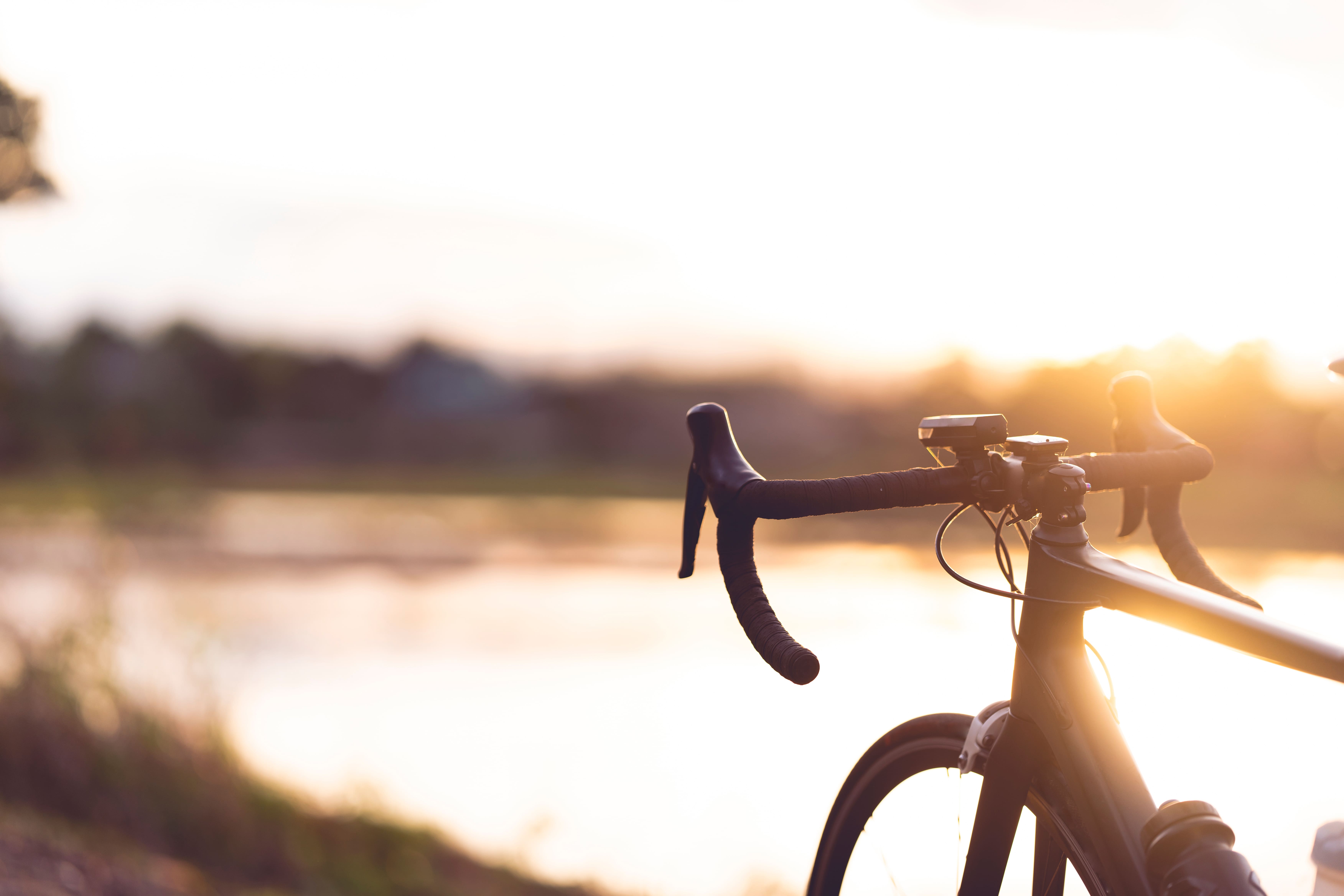 Road bike parked by a lakeside at sunset with warm light