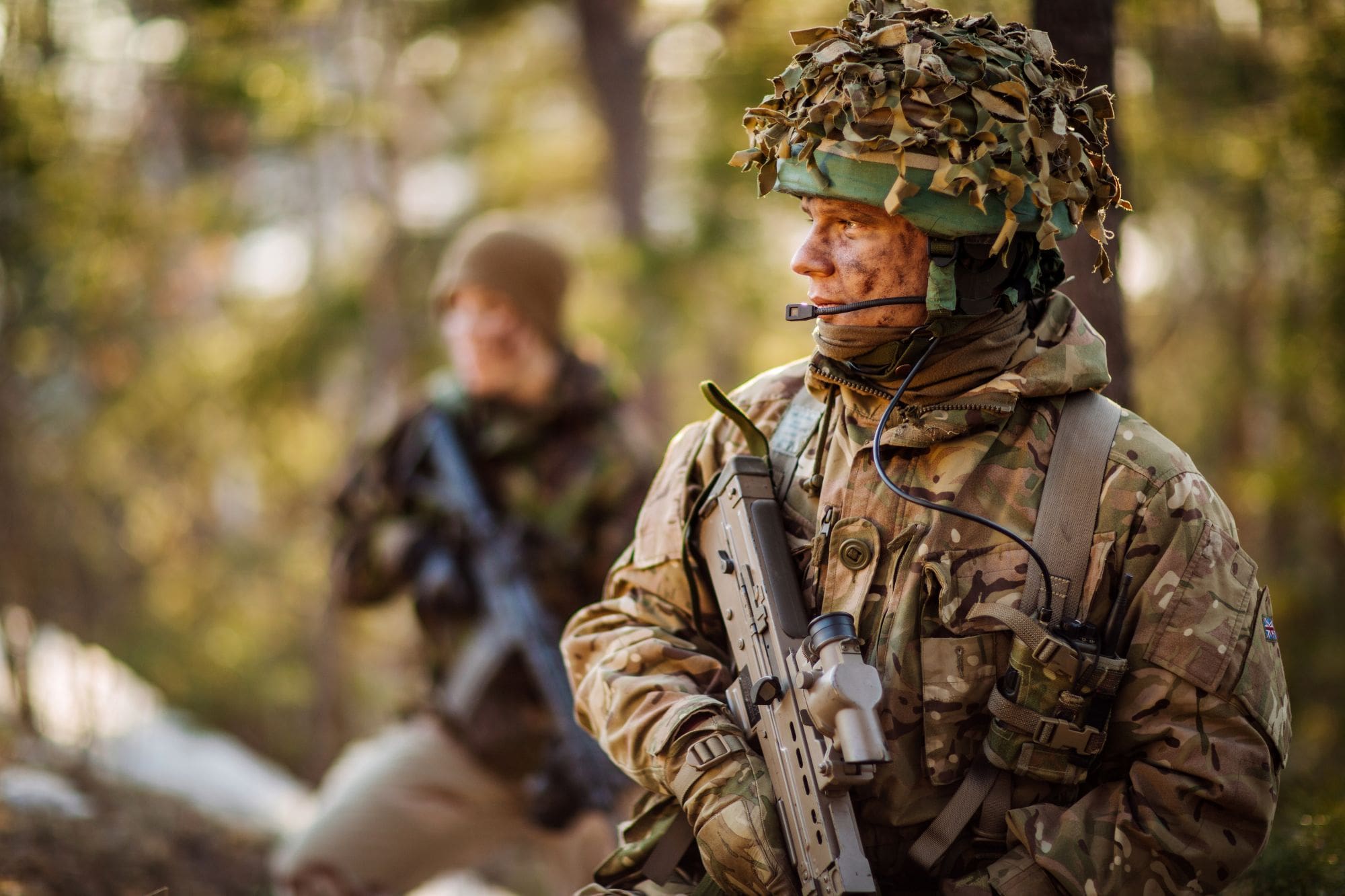 military serviceman in camouflage holding weapon.