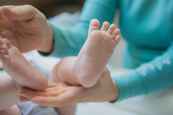 Adult hands holding baby's feet
