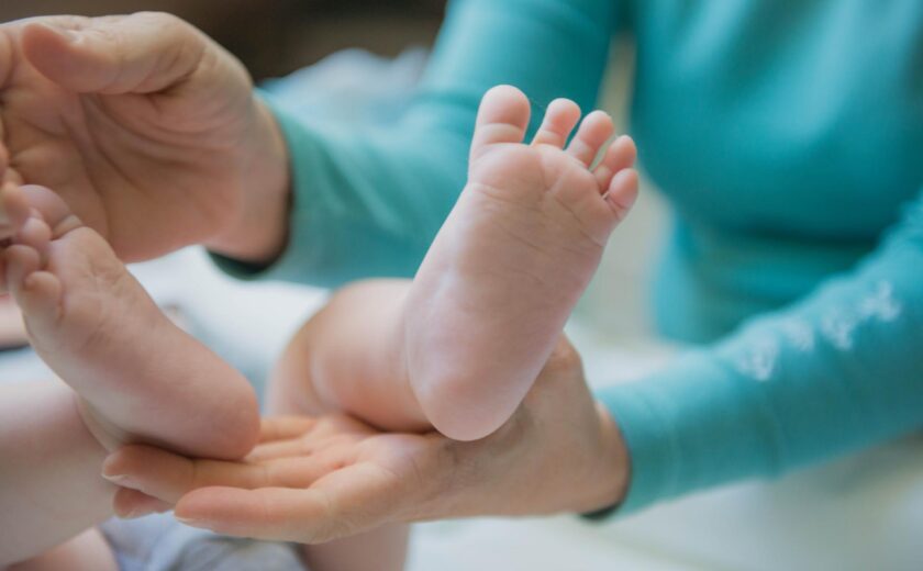 Adult hands holding baby's feet