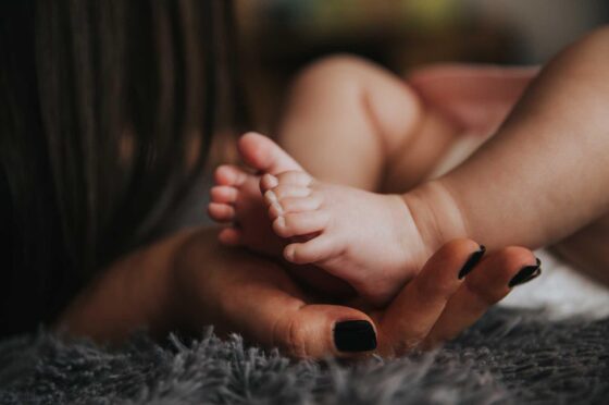 Adult holding baby's feet