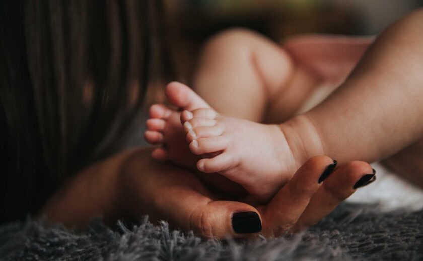 Adult holding baby's feet