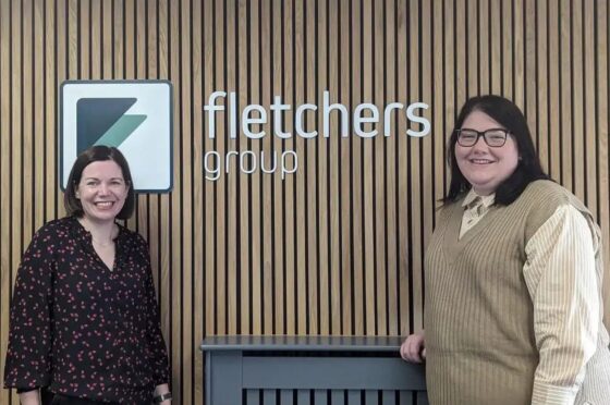 Amy and Vicki standing by Fletchers Group sign