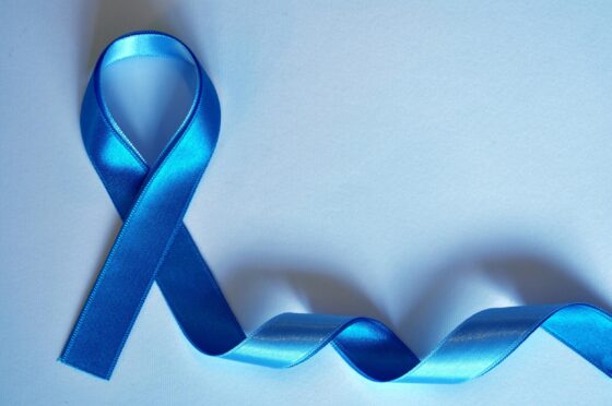 Blue awareness ribbon on blue background