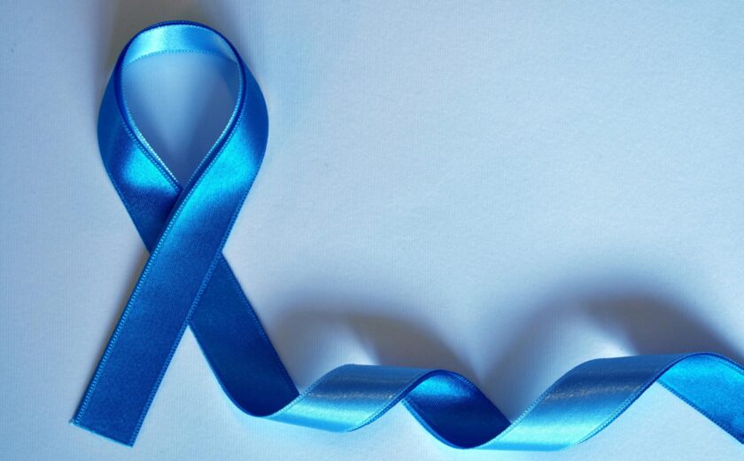 Blue awareness ribbon on blue background