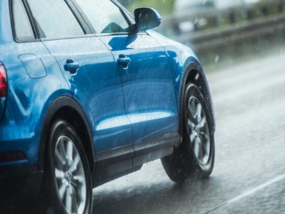 Blue car driving in rain