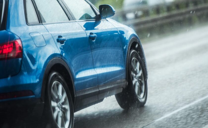 Blue car driving in rain