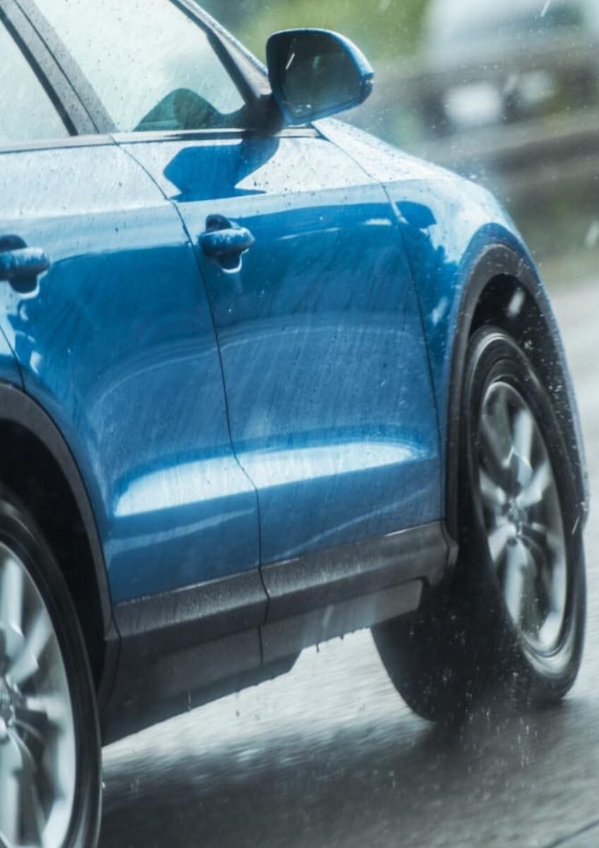 Blue car driving in rain