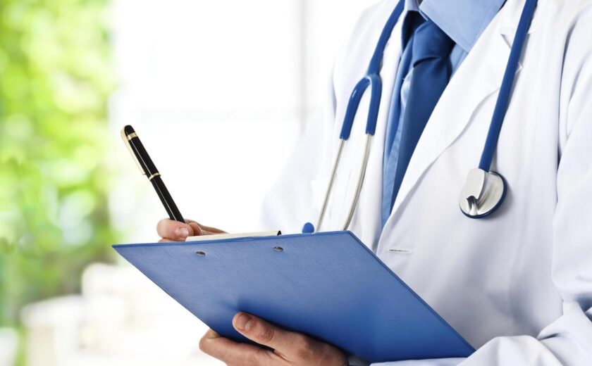 Clinician holding clipboard during medical appointment
