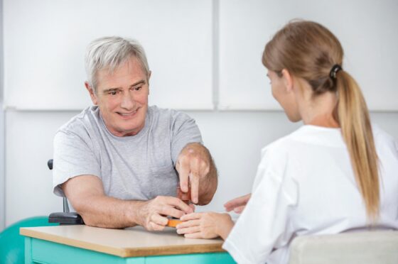 Clinician supporting man during hand therapy