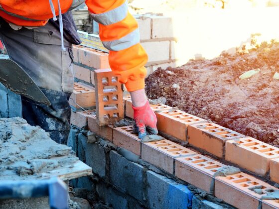 Construction worker laying bricks on site