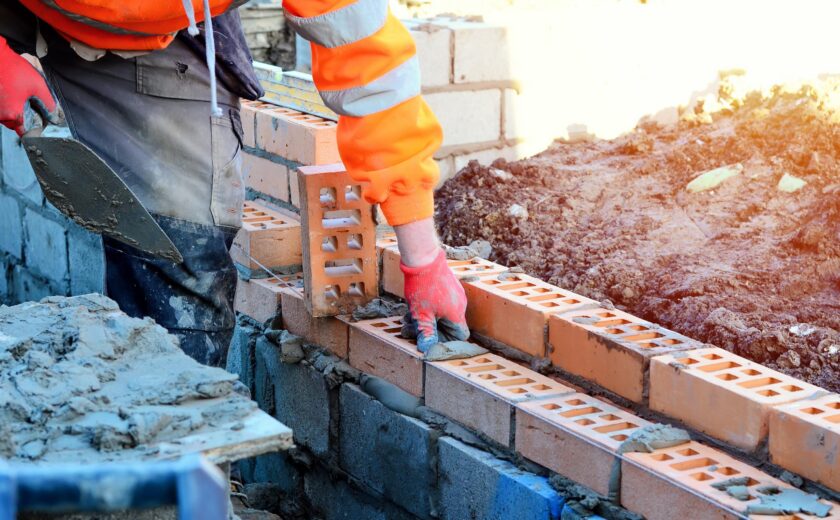Construction worker laying bricks on site
