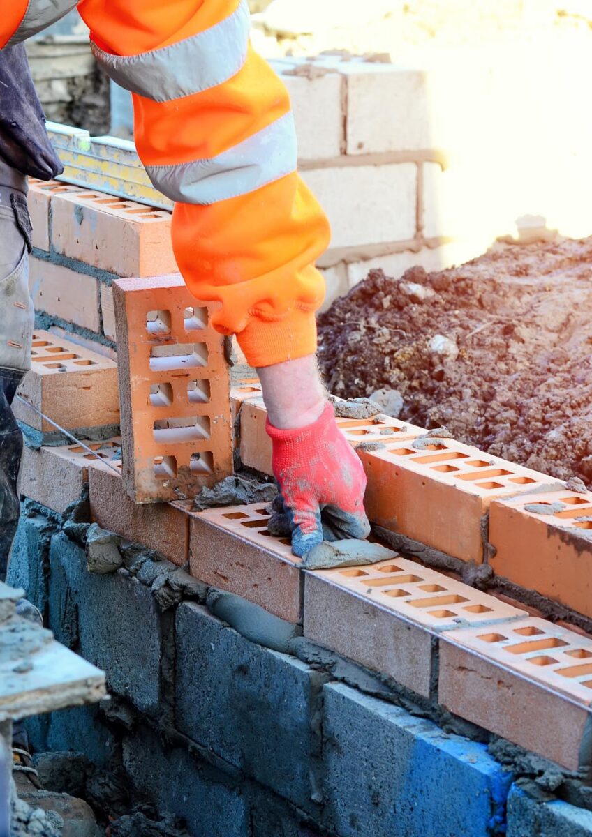 Construction worker laying bricks on site