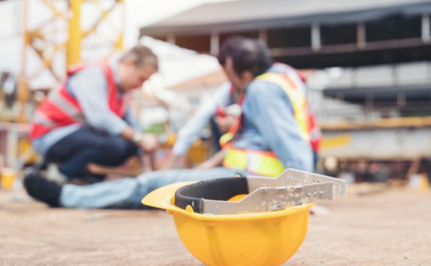 Construction workers assisting injured colleague on site