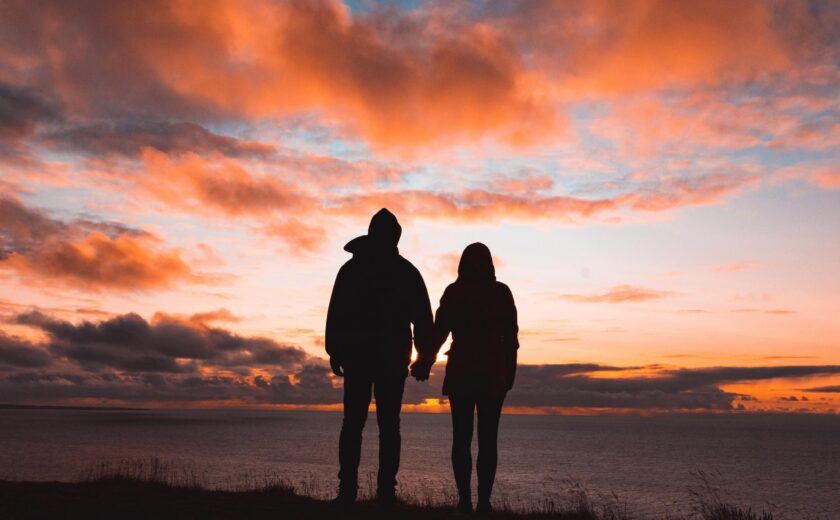 Couple silhouette holding hands at sunset