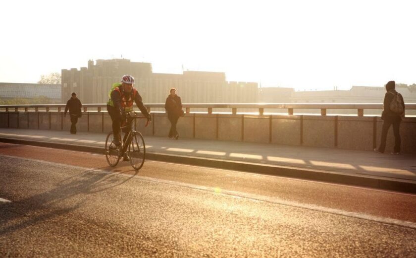 Cyclist riding over bridge at sunset