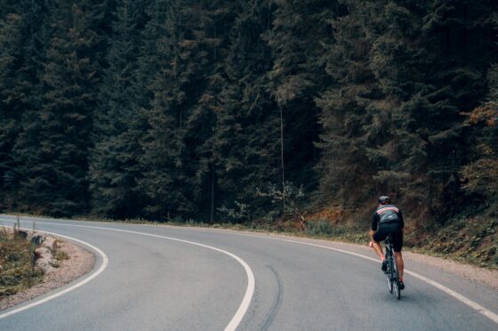 Cyclist riding through forest bend