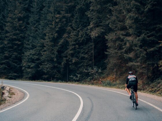 Cyclist riding through forest bend