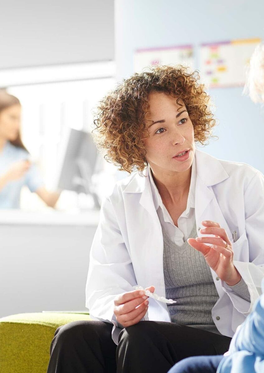 Doctor advising older patient in clinic waiting area