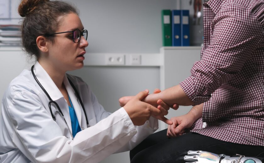Doctor examining patient's hand in consultation