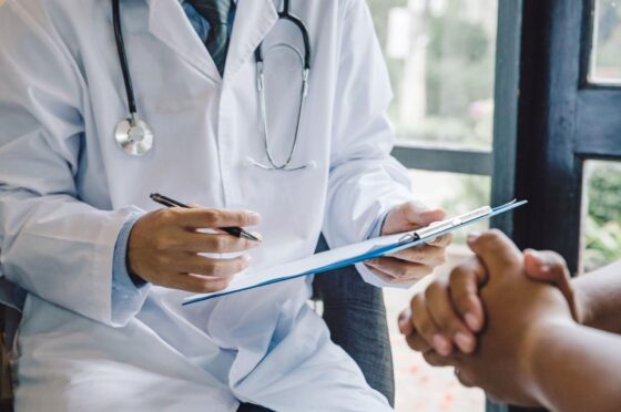 Doctor taking notes during patient consultation