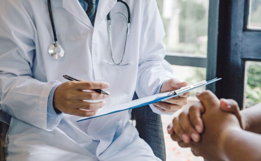 Doctor taking notes during patient consultation