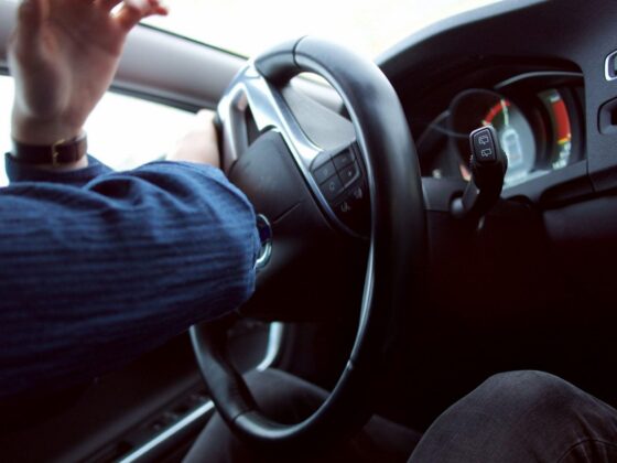 Driver holding steering wheel on road