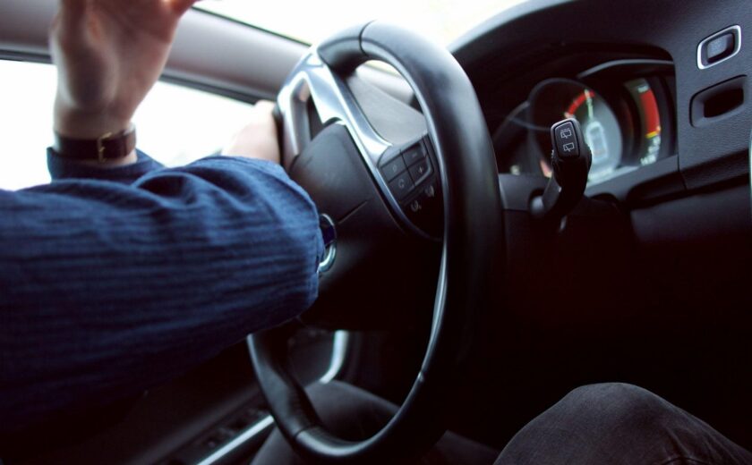 Driver holding steering wheel on road