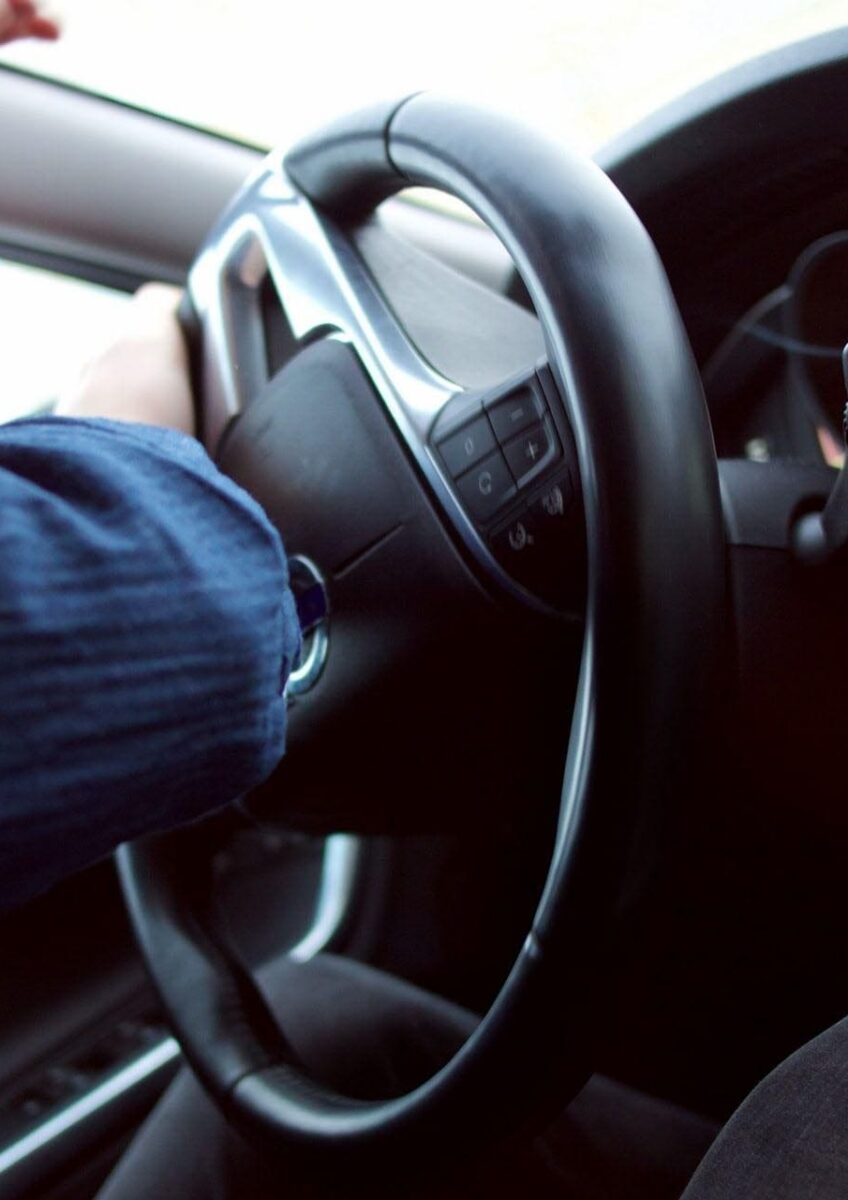 Driver holding steering wheel on road