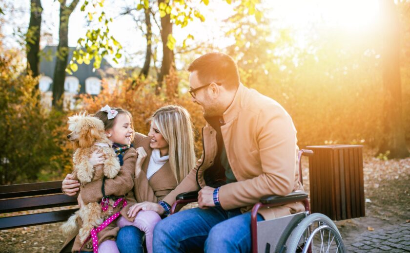 Family with child using wheelchair in park