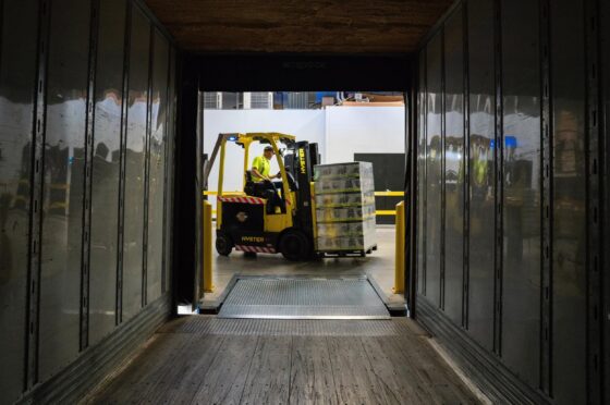 Forklift loading pallets inside lorry