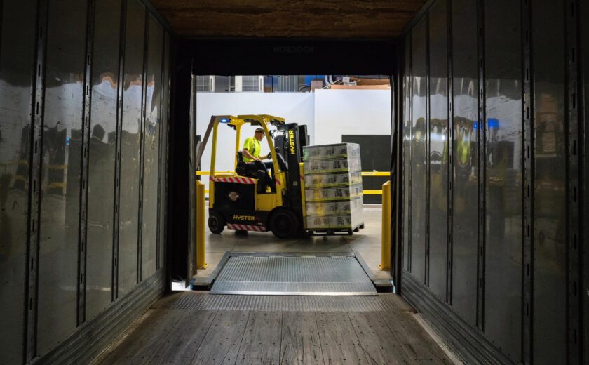Forklift loading pallets inside lorry