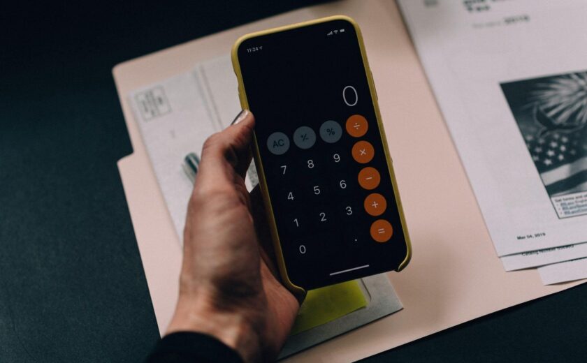 Hand using calculator on smartphone