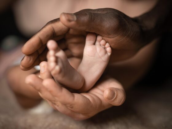 Hands cradling newborn baby's feet