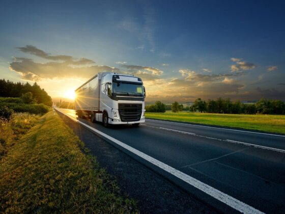 HGV driving along road at sunset